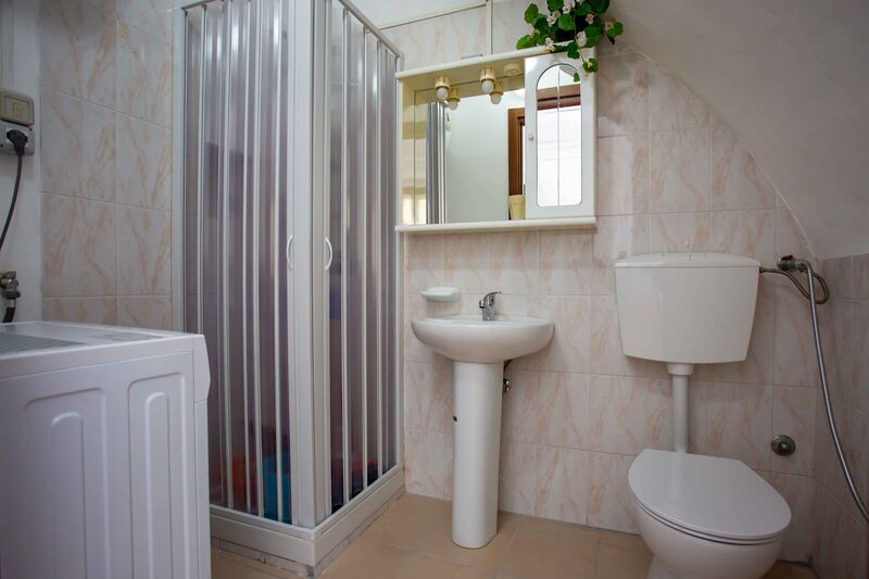 Il bagno con box doccia, lavabo e lavatrice