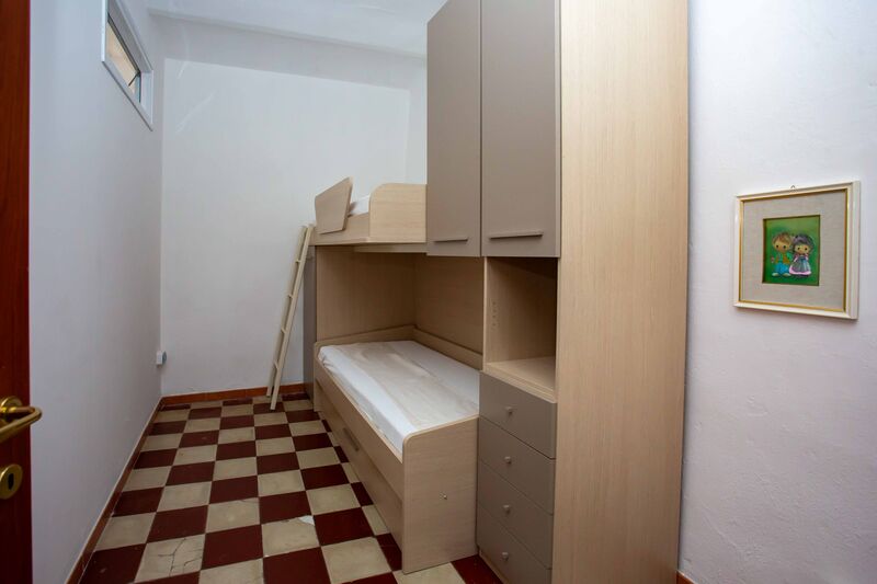 La camera con il letto a castello e il pavimento a scacchi