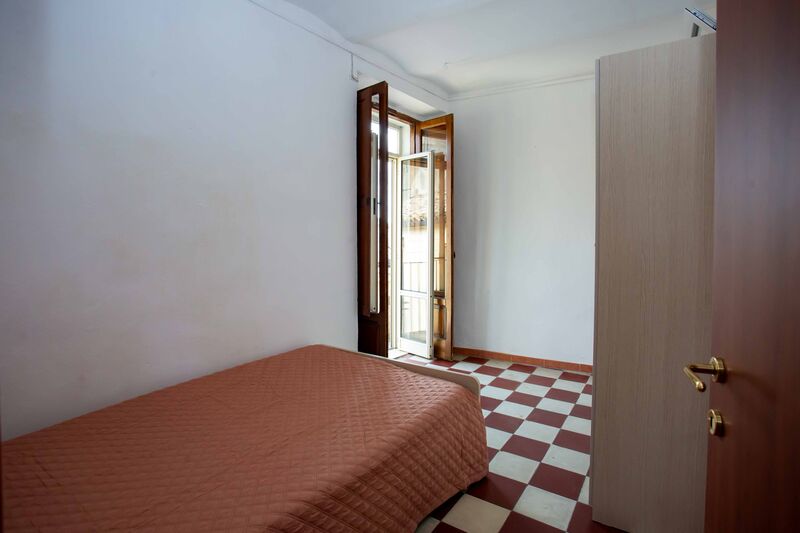 La camera con il letto a una piazza e mezza e la finestra sul vicolo