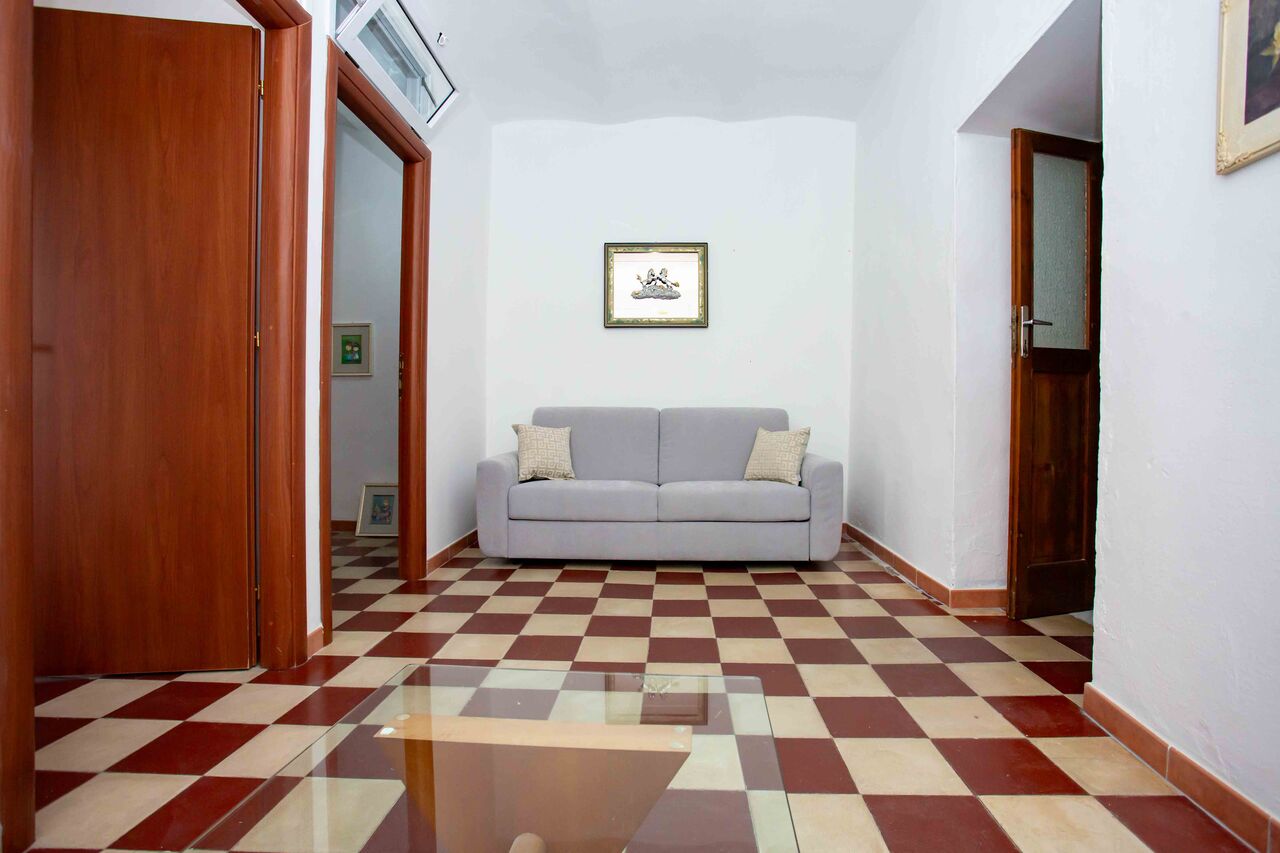 Il corridoio di Domus Rosae con il pavimento a scacchi mattone e crema, verso il soggiorno