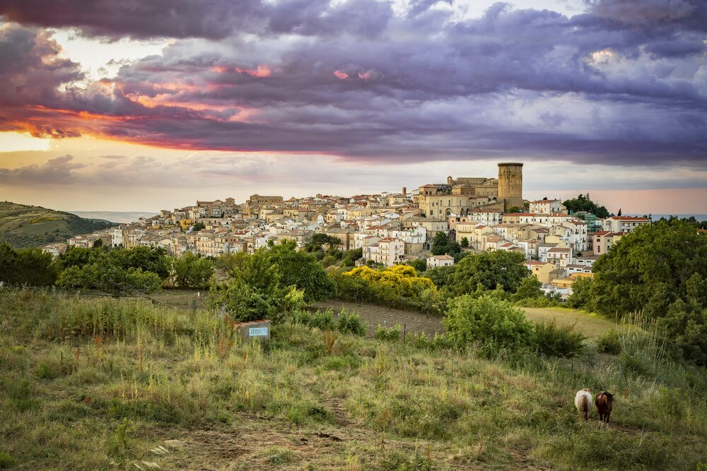 Veduta di Tricarico al tramonto: il paese disteso sul crinale, dominato dalla Torre Normanna